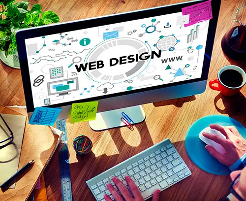 עמדת עבודה לבניית אתרים — מסך עם איורי web design, מקלדת וקפה